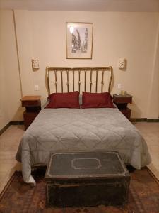 Schlafzimmer mit einem großen Bett mit einem Kopfteil aus Holz in der Unterkunft Taylor's 2 Desembarco en La Ciudad Vieja in Montevideo