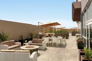 a patio with chairs and tables and an umbrella at Hampton Inn By Hilton Monterrey Apodaca in Monterrey