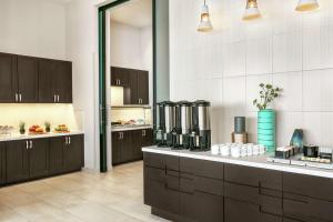 a large kitchen with black cabinets and a counter at Hampton Inn By Hilton Monterrey Apodaca in Monterrey