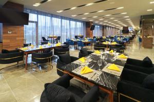 une salle à manger avec des tables, des chaises et des fenêtres dans l'établissement Hilton Garden Inn Monterrey Obispado, à Monterrey