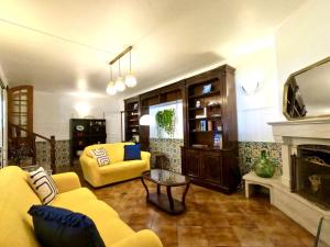 a living room with a yellow couch and a fireplace at Yucca House Carcavelos Beach in Carcavelos