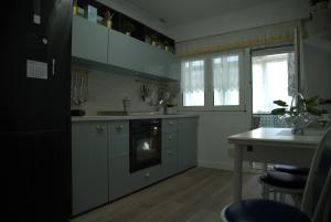 a kitchen with gray cabinets and a table and a window at ApartamentoLillos in Luanco