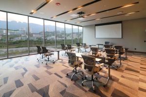 una sala de conferencias con mesas, sillas y una pizarra en Hilton Garden Inn Monterrey Obispado en Monterrey