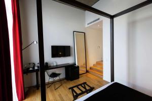 um quarto com uma cama, uma televisão e um espelho em Anselmo Buenos Aires, Curio Collection by Hilton em Buenos Aires