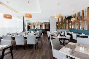 a dining room with tables and chairs and chandeliers at Hilton Garden Inn Salamanca in Salamanca