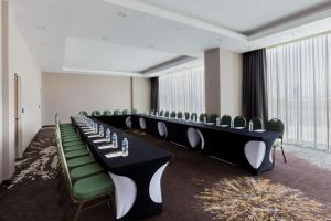 une rangée de tables et de chaises dans une pièce dans l'établissement Hilton Garden Inn Salamanca, à Salamanca