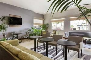 una sala de espera con mesas y sillas y un sofá en Hilton Garden Inn Queretaro, en Querétaro