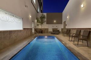 uma grande piscina num quarto com um ecrã de projecção em Hilton Garden Inn Queretaro em Querétaro