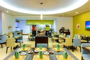 um restaurante com mesas e cadeiras e uma cafetaria em Hilton Garden Inn Queretaro em Querétaro