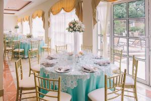 a dining room with a table and chairs and windows at Hilton Princess Managua in Managua