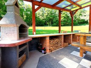 a patio with an outdoor oven and a picnic table at Chata Vikinka - dovolená v přírodě 