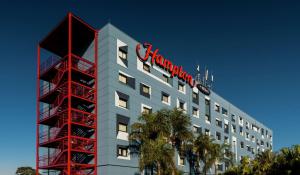 瓜鲁柳斯Hampton by Hilton Guarulhos Airport的顶部有标志的建筑物
