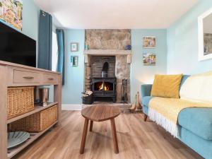 a living room with a couch and a fireplace at Flintstone Cottage in Penzance