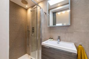 W łazience znajduje się umywalka i prysznic. w obiekcie Beautiful 2-Bed Apartment in London w Londynie