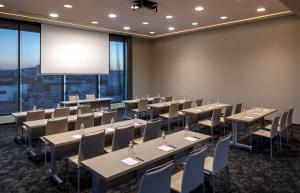 a conference room with tables and chairs and a large screen at Hilton DoubleTree Guadalajara Centro Historico in Guadalajara