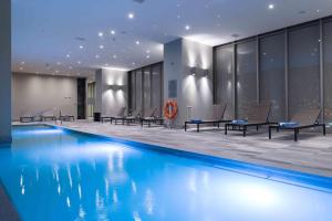 a swimming pool in a hotel with chairs around it at Hilton Garden Inn Iquique in Iquique