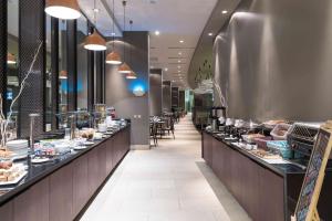 a restaurant with a long line of counters with food at Hilton Garden Inn Iquique in Iquique