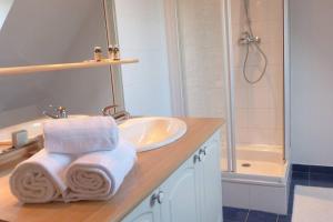 a bathroom with a sink and a shower with towels at Ty Kerigan, Maison 3* proche de la plage - Locmariaquer in Locmariaquer