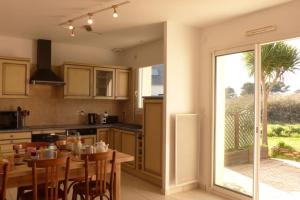 a kitchen with a wooden table and a dining room at Ty Kerigan, Maison 3* proche de la plage - Locmariaquer in Locmariaquer