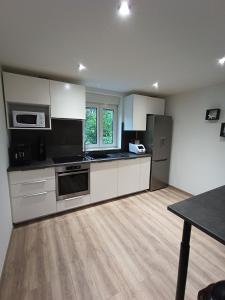 a kitchen with stainless steel appliances and a wooden floor at Maison de ville avec terrasse in Épinal
