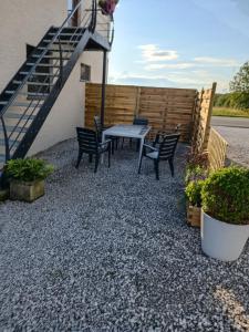 eine Terrasse mit einem Tisch, Stühlen und Treppen in der Unterkunft Gîte Ferme d'hurtaux in Froidchapelle