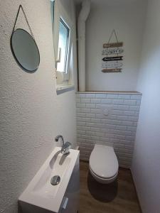 a bathroom with a white toilet and a sink at Maison de ville avec terrasse in Épinal