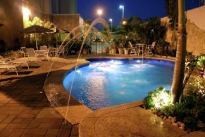 a swimming pool with a fountain in a hotel at Hampton Inn Tampico Airport in Tampico