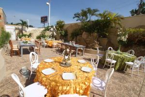 un patio con una mesa, sillas y mesas blancas y una registradora en Hampton Inn Tampico Airport en Tampico