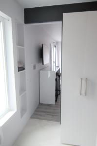 a white kitchen with a refrigerator and a table at Silva Domus in West Orange