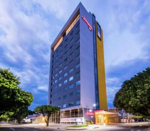 un grand bâtiment d'hôtel avec un panneau sur celui-ci dans l'établissement Hampton By Hilton Cucuta, à Cúcuta
