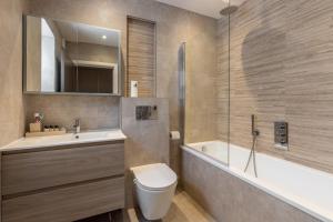 a bathroom with a toilet and a sink and a tub at Remarkable 2-Bed Apartment in London in London