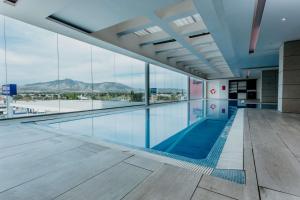 a swimming pool in a building with a view at Hilton Garden Inn Silao Aeropuerto Bajio in Silao