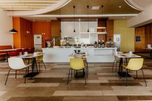 a restaurant with tables and chairs and a kitchen at Hilton Garden Inn Silao Aeropuerto Bajio in Silao