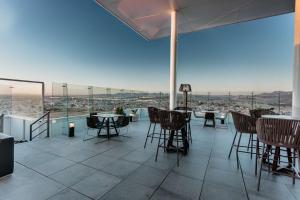 a patio with tables and chairs and a view of the city at Hilton Garden Inn Silao Aeropuerto Bajio in Silao