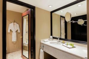 La salle de bains est pourvue d'un lavabo et d'un miroir. dans l'établissement Hilton Mexico City Airport, à Mexico