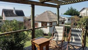 eine Veranda mit 2 Stühlen und ein Haus in der Unterkunft Moana in Punta Del Diablo + 6 Fotos