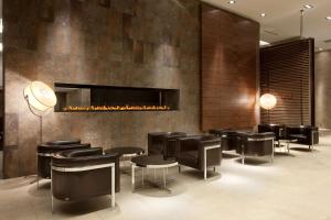 a lobby with black chairs and a fireplace at Hilton Garden Inn Santiago Airport in Santiago