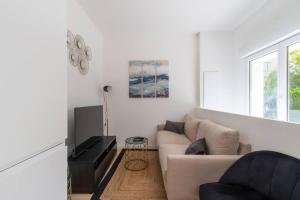 sala de estar blanca con sofá y TV en sousplex Cosy - proche tram et Corum - CLIM, en Montpellier