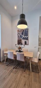 a dining room table with chairs and a black light fixture at Remanso de luz y silencio en plena Puerta del Sol in Madrid