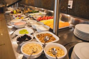 ein Buffet mit Schalen mit Speisen und Tellern in der Unterkunft Hilton Garden Inn Leon Poliforum in León