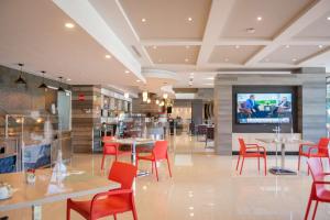 a restaurant with tables and chairs and a flat screen tv at Hilton Garden Inn Leon Poliforum in León