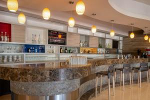 a bar in a restaurant with stools at Hilton Garden Inn Leon Poliforum in León