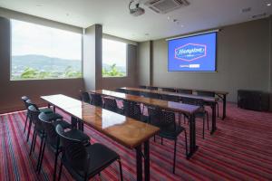 una sala de conferencias con mesas, sillas y una pantalla en Hampton By Hilton Yopal en Yopal