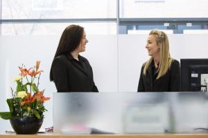 two women standing next to each other in an office at Woodland Grange in Leamington Spa