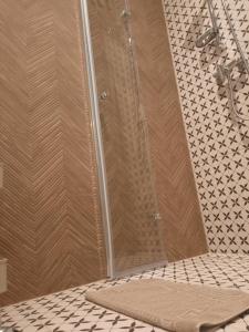 a shower in a bathroom with a tile floor at Ukiel Park Apartament Kozetka in Olsztyn