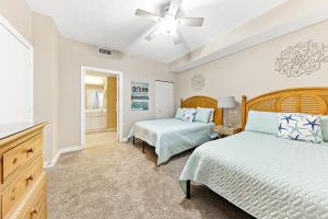 a bedroom with two beds and a ceiling fan at Beach Colony E10B in Pensacola