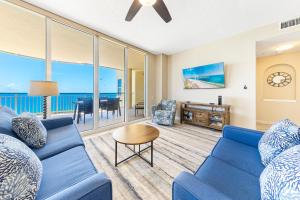 a living room with a blue couch and a table at Beach Colony E10B in Pensacola +57 photos