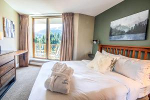 a bedroom with a bed and a large window at Cascade in Whistler