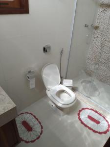 a bathroom with a toilet with red and white rugs at Sítio Olho de Boneca in Itamonte +43 photos