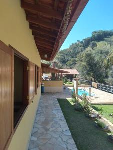 ein Haus mit einem Gehweg neben einem Pool in der Unterkunft Sítio Olho de Boneca in Itamonte